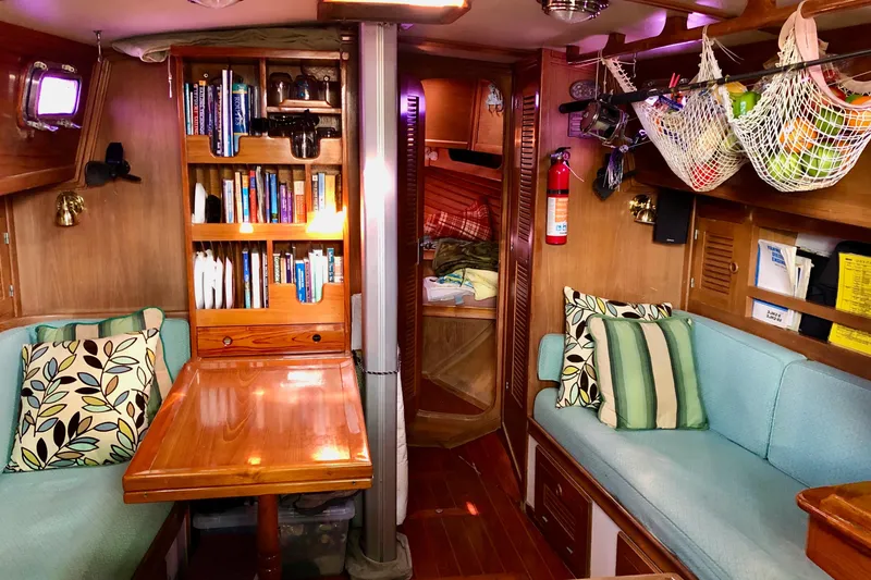 Slide: The Image of Cozy interior of 1989 Cabo Rico 34 sailboat with bookshelves and seating area. - 27