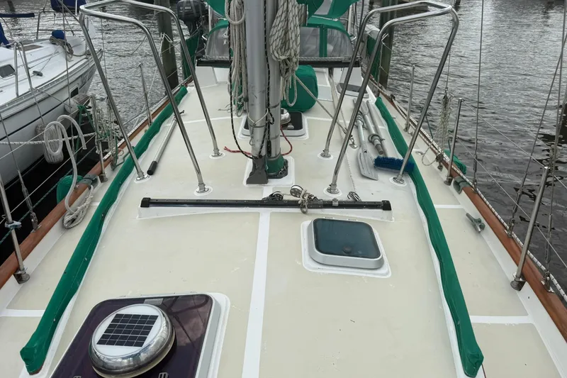 Slide: The Image of 1989 Cabo Rico 34 sailboat deck with green trim, docked at marina. - 7