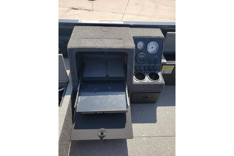 Slide: The Image of 2024 Crestliner 1650 Pro Tiller dashboard with open storage and control panel. - 10