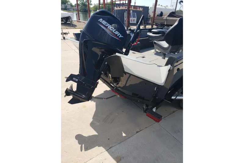 Slide: The Image of 2024 Crestliner 1650 Pro Tiller boat with Mercury outboard motor, parked on concrete. - 12