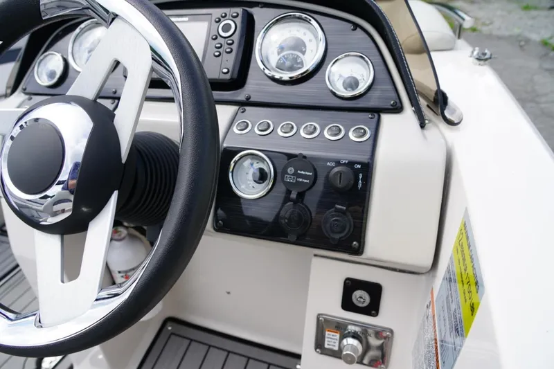 Slide: The Image of 2019 Starcraft Star Step 221 E I/O boat dashboard with steering wheel and control panel. - 16
