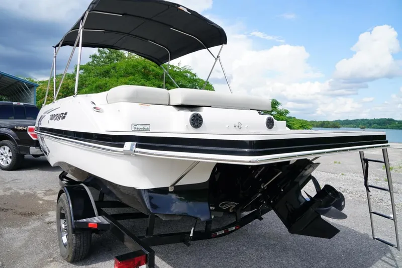 Slide: The Image of 2019 Starcraft Star Step 221 E I/O boat on trailer by a lake. - 19