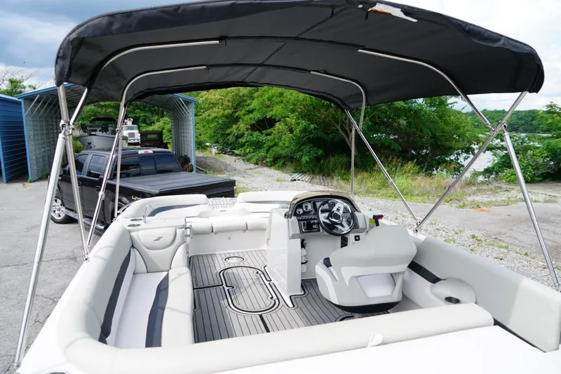 Slide: The Image of 2019 Starcraft Star Step 221 E I/O boat with canopy, parked near a lake. - 23