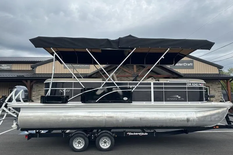 The Image of 2022 Bennington 22 SSRX pontoon boat with black canopy on trailer. - 0