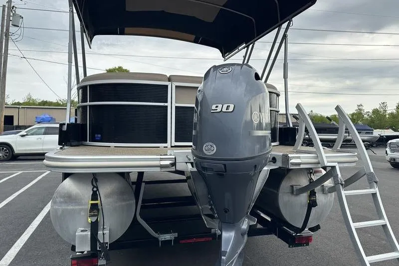 Slide: The Image of 2022 Bennington 22 SSRX pontoon boat with Yamaha 90 engine, parked outdoors. - 2