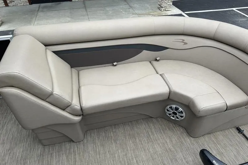 Slide: The Image of Luxurious seating on a 2022 Bennington 22 SSRX pontoon boat, featuring beige upholstery and speaker. - 6