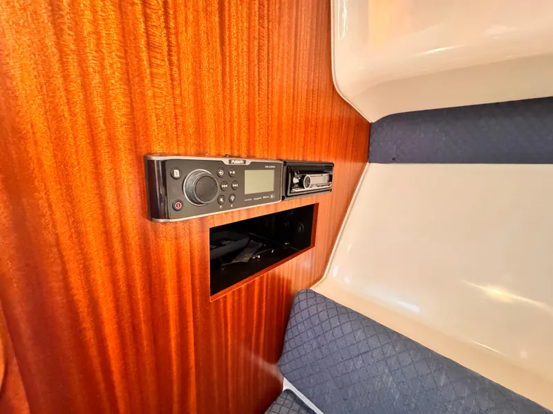 Slide: The Image of 2014 Pursuit OS 385 Offshore cabin interior with wood paneling and audio system. - 10