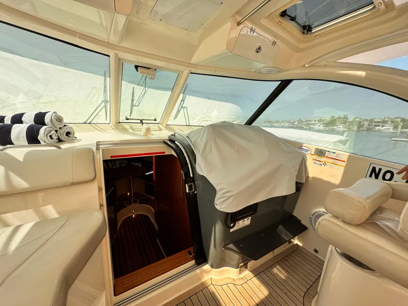 Slide: The Image of Interior of a 2014 Pursuit OS 385 Offshore boat with seating and cabin entrance. - 18