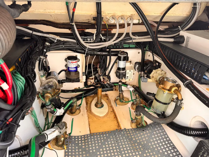 Slide: The Image of Engine room of a 2014 Pursuit OS 385 Offshore boat, showcasing mechanical components and wiring. - 29