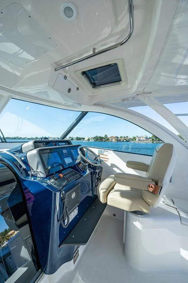 Slide: The Image of 2014 Pursuit OS 385 Offshore helm with modern controls and ocean view. - 3