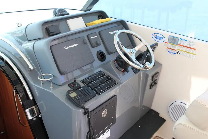 Slide: The Image of 2014 Pursuit OS 385 Offshore helm with Raymarine electronics and steering wheel. - 5