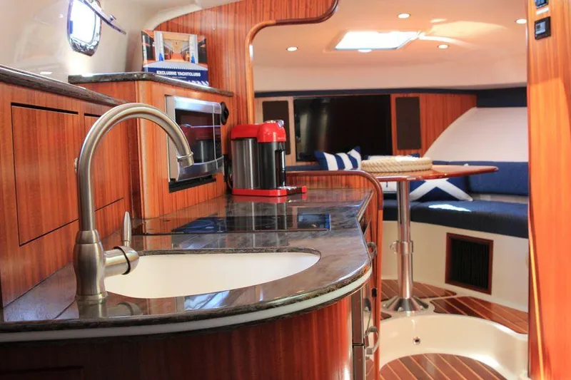 Slide: The Image of 2014 Pursuit OS 385 Offshore yacht interior with kitchenette and seating area. - 7