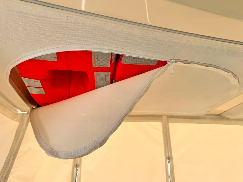 Slide: The Image of 2014 Pursuit OS 385 Offshore boat storage compartment with red life jackets. - 8