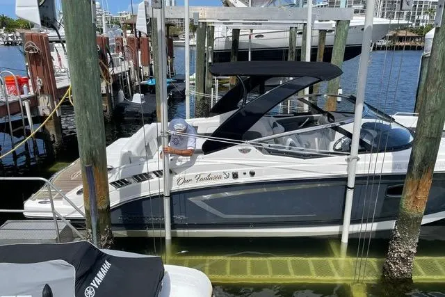 Slide: The Image of 2014 Chaparral 307 SSX boat docked at marina with Yamaha equipment nearby. - 2