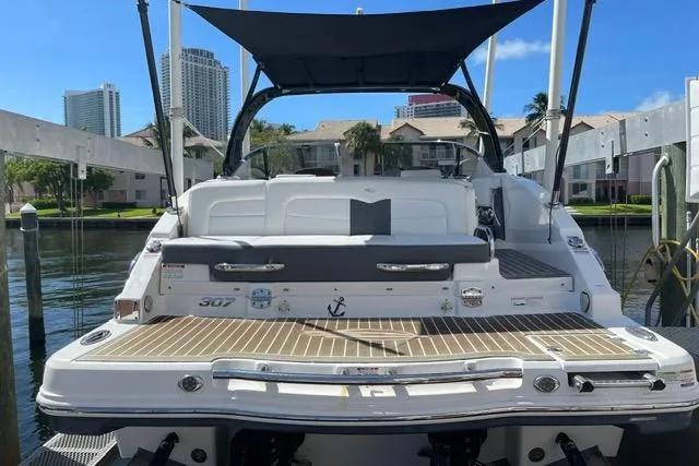 Slide: The Image of 2014 Chaparral 307 SSX boat docked, featuring spacious deck and canopy. - 3