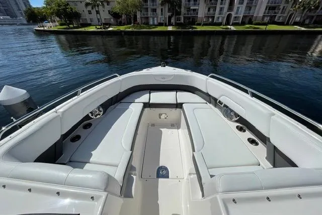 Slide: The Image of 2014 Chaparral 307 SSX boat with spacious seating, docked by waterfront apartments. - 5