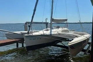 The Image of 1994 Corsair F24 MKI trimaran docked on a sunny day by the water. - 1