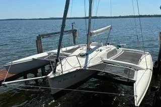Slide: The Image of 1994 Corsair F24 MKI trimaran sailboat docked on a calm lake. - 8
