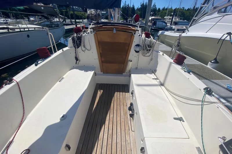Slide: The Image of Cockpit of 1980 Pacific Seacraft Orion 27 sailboat with wooden flooring and ropes. - 11