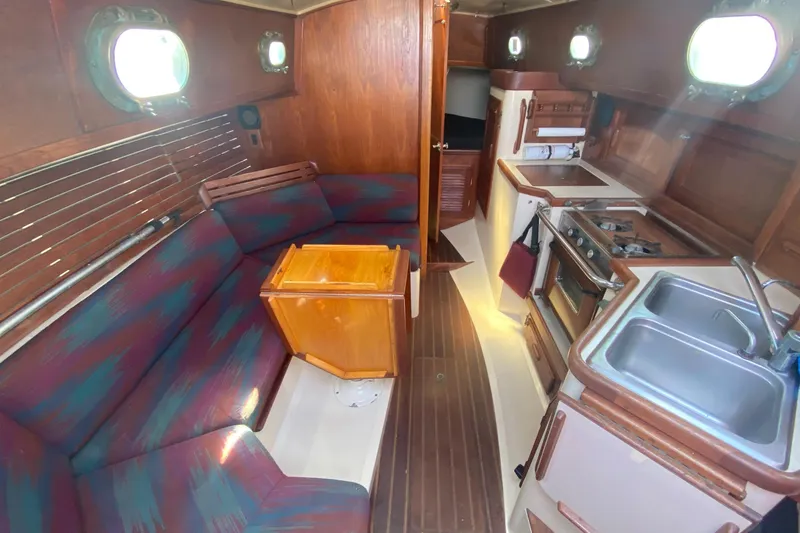 Slide: The Image of Interior of a 1980 Pacific Seacraft Orion 27 yacht with kitchen and seating area. - 13