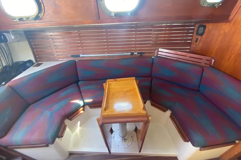 Slide: The Image of Cozy interior of 1980 Pacific Seacraft Orion 27 sailboat with colorful seating and wooden table. - 14