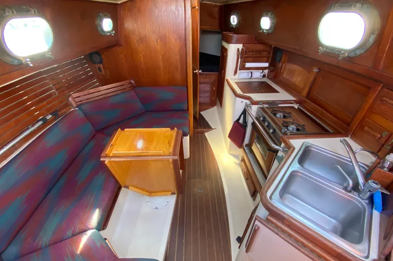 Slide: The Image of Interior of 1980 Pacific Seacraft Orion 27 sailboat with cozy seating and compact kitchen. - 18