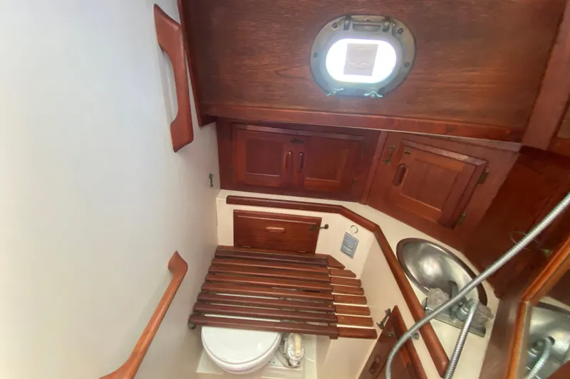 Slide: The Image of Interior of 1980 Pacific Seacraft Orion 27 sailboat bathroom with wooden cabinetry. - 20