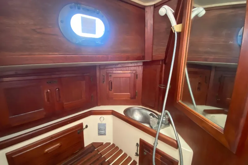 Slide: The Image of Interior of 1980 Pacific Seacraft Orion 27 sailboat with wooden cabinetry and sink. - 21