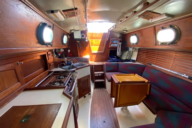 Slide: The Image of Interior of 1980 Pacific Seacraft Orion 27 sailboat with wood finish and cozy seating area. - 23