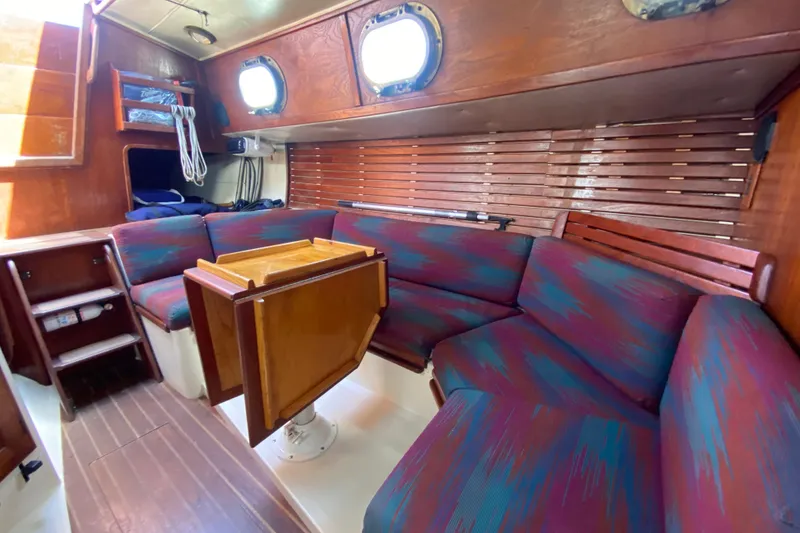 Slide: The Image of Interior of 1980 Pacific Seacraft Orion 27 sailboat with cozy seating and wooden accents. - 25