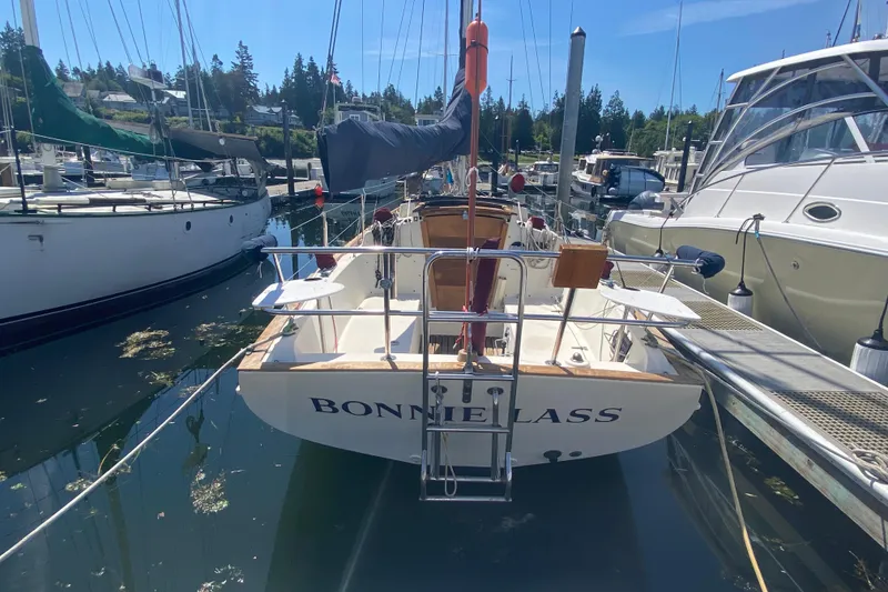 Slide: The Image of 1980 Pacific Seacraft Orion 27 sailboat docked in a marina, named "BONNIE LASS". - 3