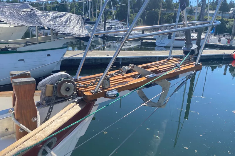 Slide: The Image of 1980 Pacific Seacraft Orion 27 sailboat bow with anchor and docked boats in background. - 5