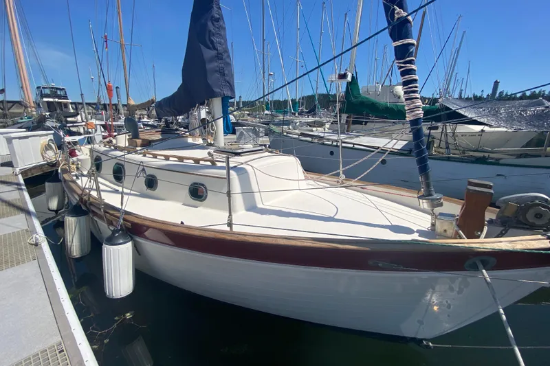 Slide: The Image of 1980 Pacific Seacraft Orion 27 sailboat docked in a marina under clear blue skies. - 6