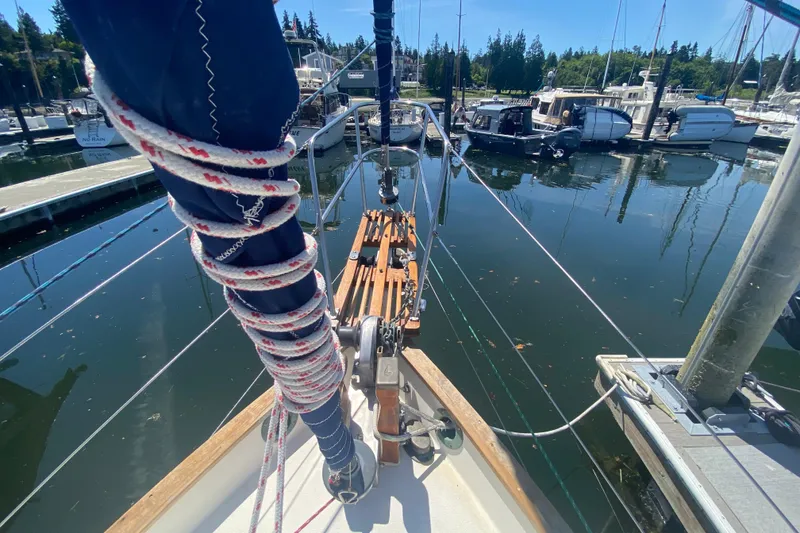 Slide: The Image of 1980 Pacific Seacraft Orion 27 sailboat docked in a marina, surrounded by watercraft. - 7