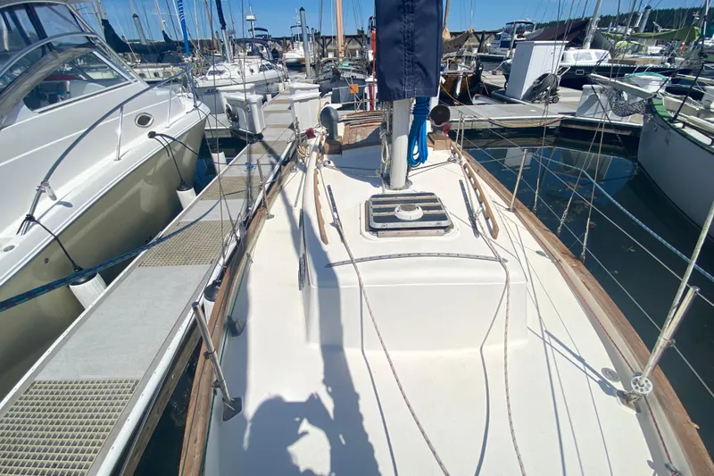 Slide: The Image of 1980 Pacific Seacraft Orion 27 sailboat docked in a marina, surrounded by other boats. - 8