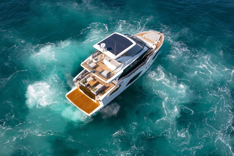 Slide: The Image of Aerial view of 2026 Absolute 52 Fly yacht cruising in clear blue waters. - 4