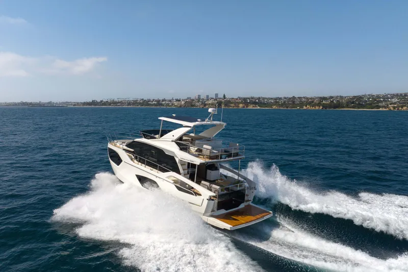 Slide: The Image of Luxury yacht Absolute 52 Fly 2026 cruising on open sea near coastline. - 2