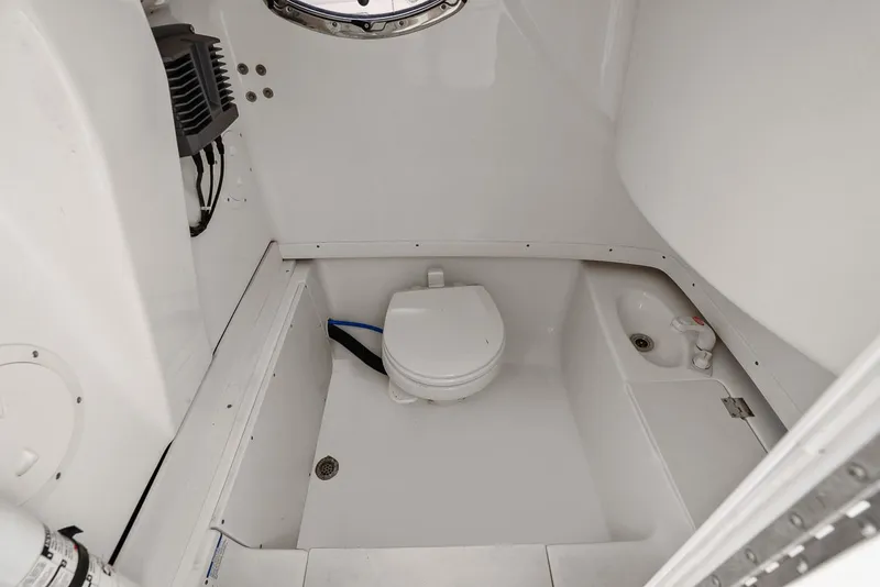 Slide: The Image of Interior of 2013 Robalo R260 Center Console with toilet and sink. - 29