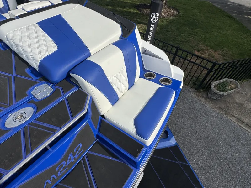 Slide: The Image of Malibu M242 2025 boat with blue and white seats and cup holders. - 11