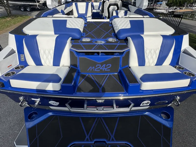 Slide: The Image of 2025 Malibu M242 boat with blue and white seating, modern design. - 9