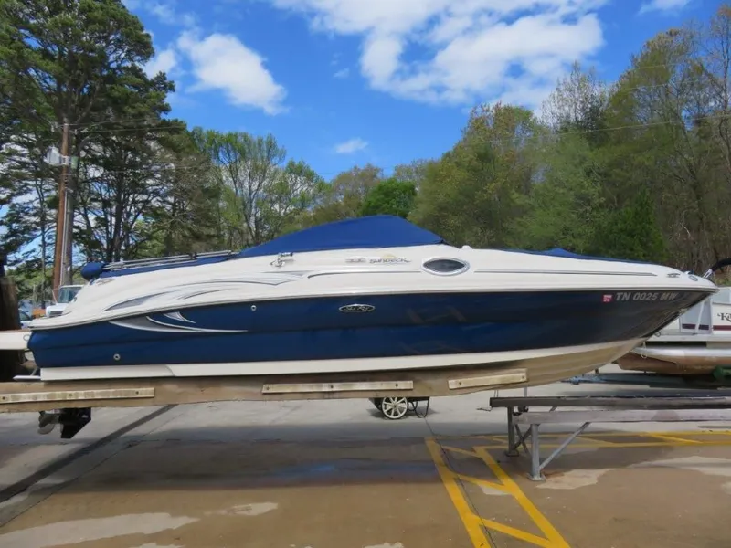 The Image of 2006 Sea Ray 240 Sundeck boat on a trailer outdoors. - 1