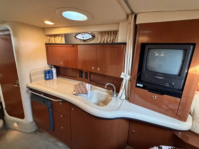 Slide: The Image of Interior of 2003 Sea Ray Sundancer 320 yacht with kitchenette and TV. - 4