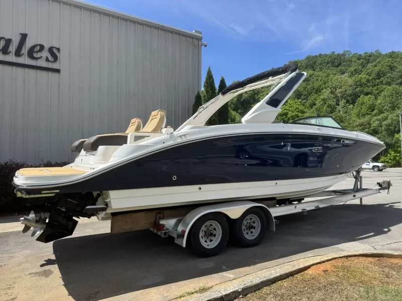 Slide: The Image of 2026 Sea Ray SDX290 boat on trailer in front of building. - 28