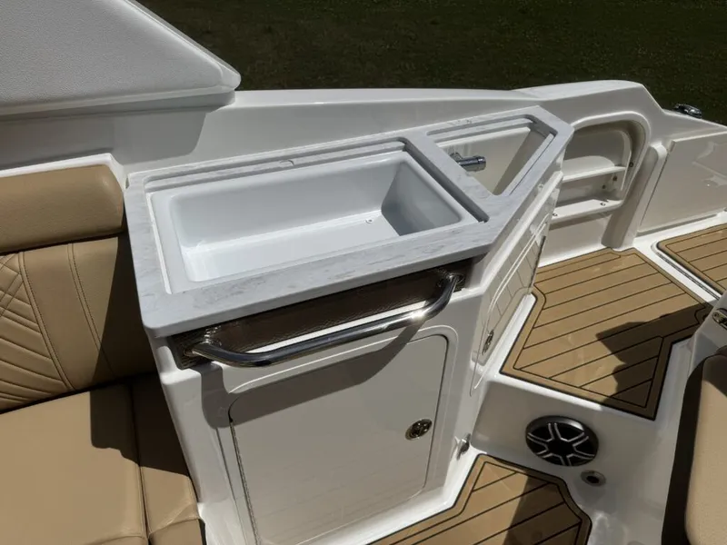 Slide: The Image of 2026 Sea Ray SDX290 boat kitchenette with sink and seating area. - 8
