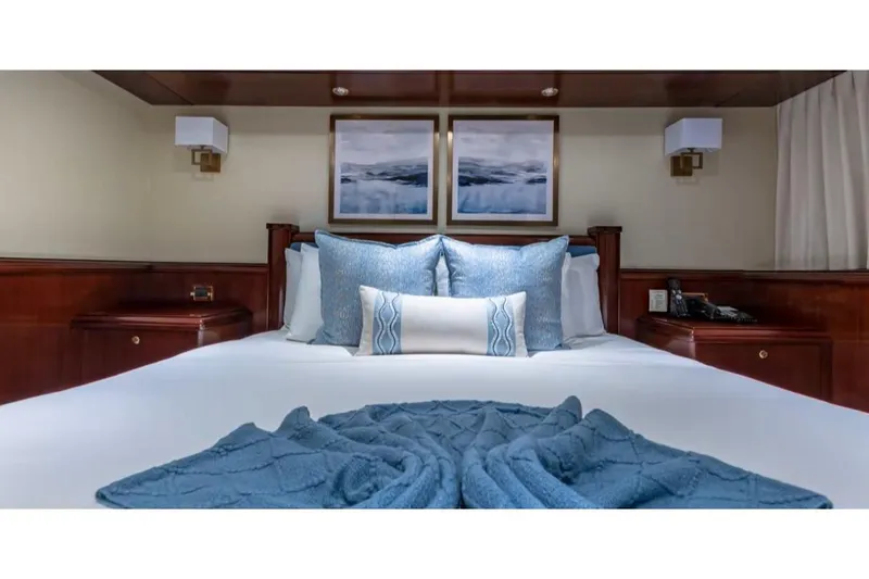 Slide: The Image of Luxurious bedroom interior on 1988 Van Mill 143 Tri-Deck Motor Yacht, featuring elegant blue decor. - 40