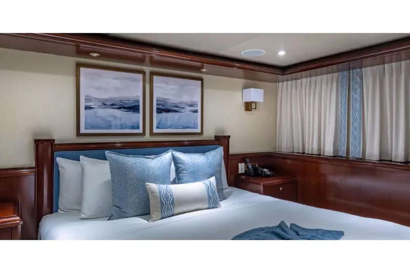 Slide: The Image of Luxurious bedroom interior on 1988 Van Mill 143 Tri-Deck Motor Yacht, featuring elegant decor and plush bedding. - 42