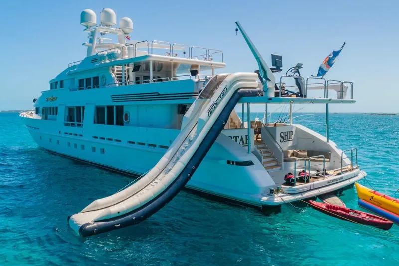 Slide: The Image of Luxurious 1988 Van Mill 143 Tri-Deck Motor Yacht with slide, anchored in clear blue waters. - 5