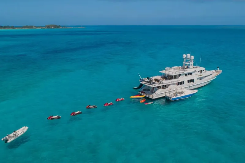 Slide: The Image of Aerial view of 1988 Van Mill 143 Tri-Deck Motor Yacht with jet skis in turquoise water. - 78