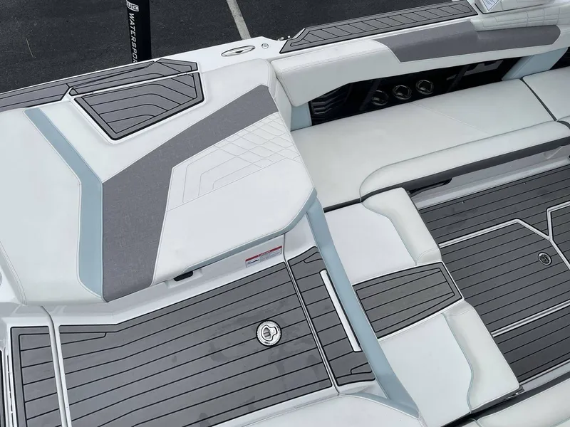 Slide: The Image of Interior of a 2022 Nautique G25 boat with gray and white upholstery. - 10