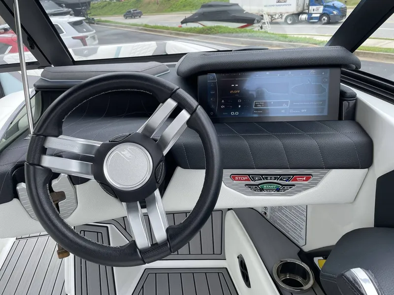 Slide: The Image of Interior view of 2022 Nautique G25 boat cockpit with steering wheel and touchscreen. - 18